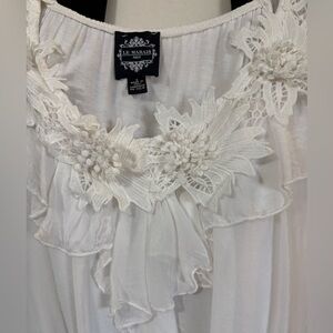 White silk made in Italy blouse. 3D flowers at v neckline. Ruffle front.
